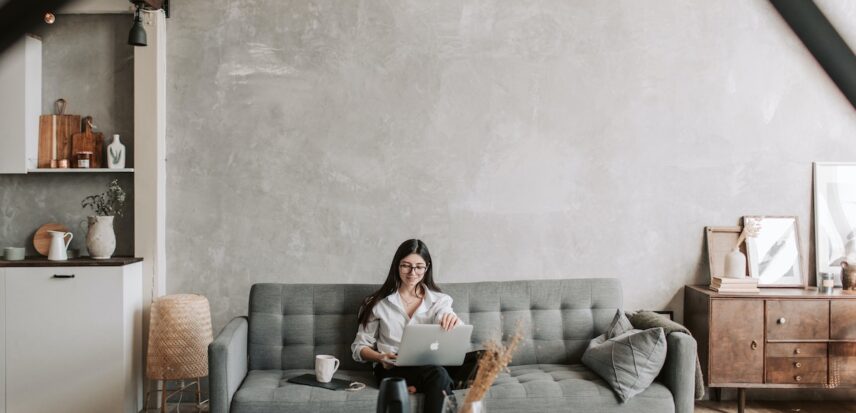 Person sitting on a couch working on a laptop